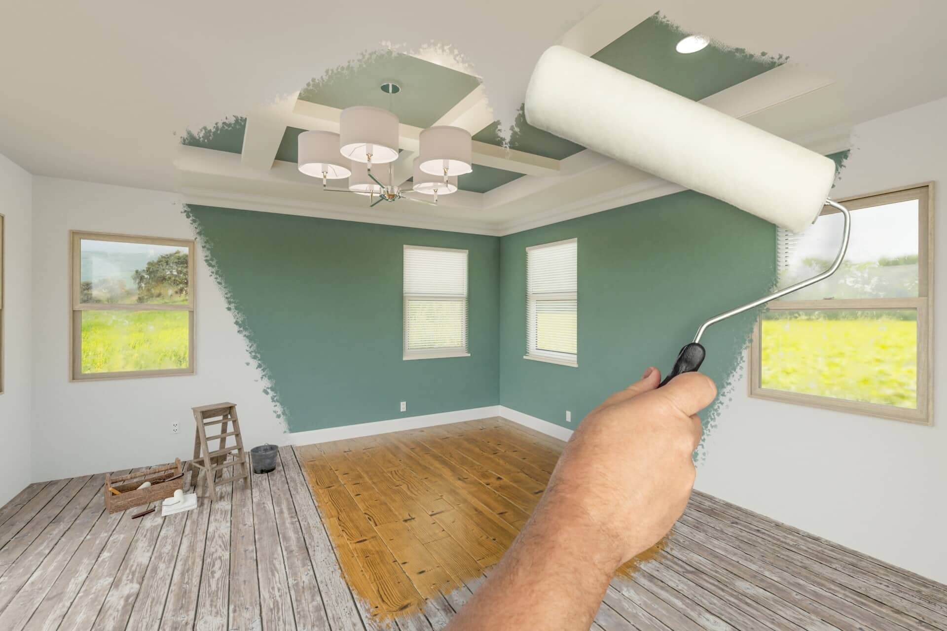 Worker painting and refinishing a room during remodeling